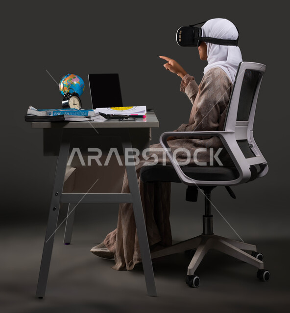 The role of technology in changing traditional education methods, expanding students’ perceptions through the use of 3D VR glasses in education, a portrait from the side of a veiled Saudi Arabian Gulf university student wearing an abaya and interacting with virtual content, black background.