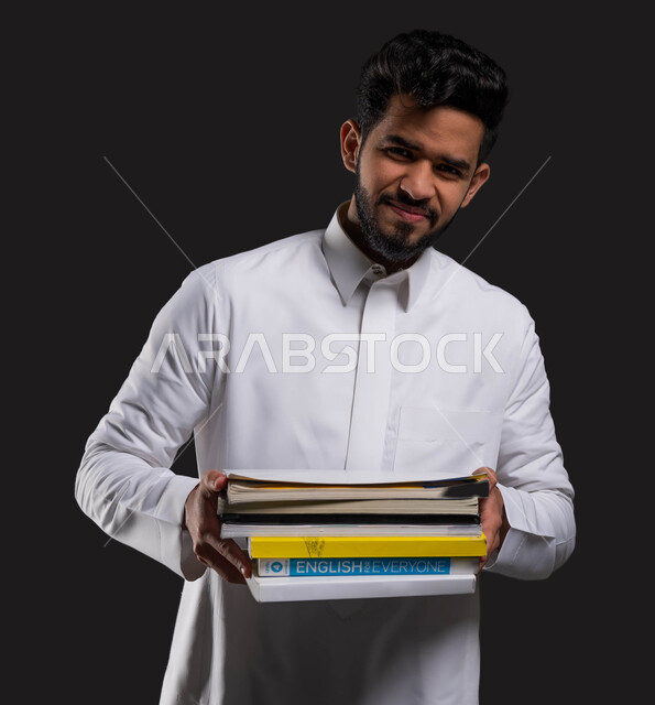 دور المدارس في توفير بيئة تعليمية آمنة ومحفزة للطلاب، السعي للتفوق والنجاح، بورتريه مقرب لطالب ثانوي عربي خليجي سعودي مبتسم يرتدي الزي التقليدي ويحمل كتبه المدرسية، العلم مفتاح التطور والنجاح، خلفية سوداء.