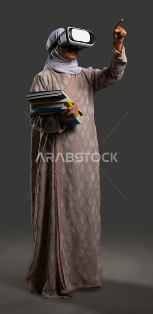 Improving student concentration through the use of virtual reality glasses in education, the development of science and education in Saudi Arabia, a close-up portrait of a veiled Saudi Arabian Gulf high school student wearing an abaya and pointing with her finger somewhere, full body image, black background.