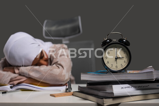 العودة إلى المدارس والجامعات، أهمية الراحة والنوم الجيد في تعزيز الصحة العقلية والجسدية للطلاب، بورتريه مقرب لطالبة ثانوي عربية سعودية خليجية ترتدي عباءة ملونة تأخذ قسط من الراحة أثناء مذاكرتها للدروس، الدراسة لساعات متأخرة في الليل، خلفية سوداء.