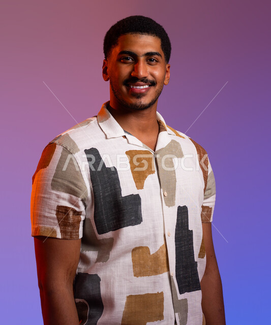 الأناقة والاهتمام بالمظهر الخارجي، إلتقاط صوره شخصية للوثائق الرسميه، بورتريه مقرب لشاب عربي خليجي سعودي مبتسم يرتدي الزي الكاجوال ينظر إلى الكاميرا بإيماءات الثقة بالنفس، الشعور بالسرور والبهجة، خلفية ملونة.