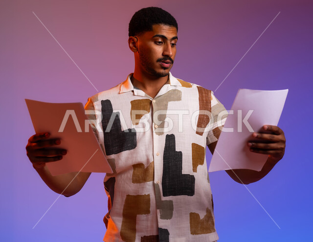 Reviewing the results of the meeting and following up on plans and projects, a portrait of a Saudi Gulf Arab man wearing a casual outfit holding a group of blank papers in his hand, gestures of focus and scrutiny in the business feasibility study, business correspondence and records, a colored background