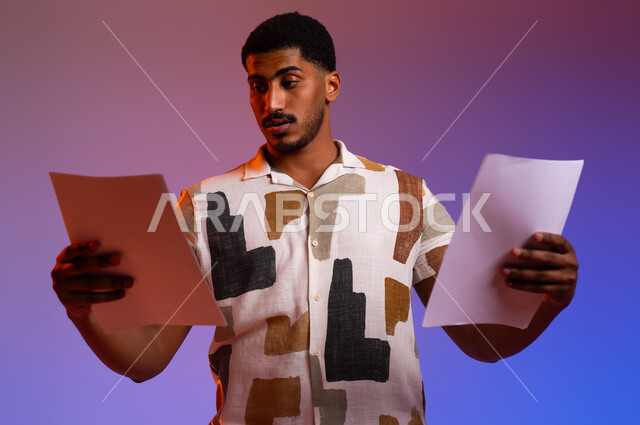 Reading notes and information, following up on plans and projects, a portrait of a Saudi Gulf Arab man wearing a casual outfit, holding a group of blank papers in his hand, gestures of focus and scrutiny, reviewing work files, a colored background