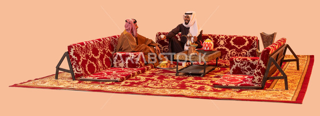 شاب يقوم بصب القهوة للضيوف، عادات عريقة في تقديم القهوة الساخنة، حورارات ونقاشات بين الأصدقاء، بورتريه لرجلان عربيان خليجيان سعوديان يرتديان الزي التقليدي يستمتعان برحلة تخييم برية، إيماءات الفرح والبشاشة وحسن الاستقبال، خلفية بيج.