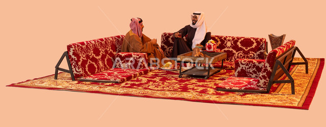 حورارات ونقاشات بين الأصدقاء، كشتة برية شبابية، بورتريه لرجلان عربيان خليجيان سعوديان يرتديان الزي التقليدي يتبادلان الحديث يتسامران، تقديم الفواكه في الجلسات الخارجية، إيماءات البشاشة وحسن الاستقبال، خلفية بيج.