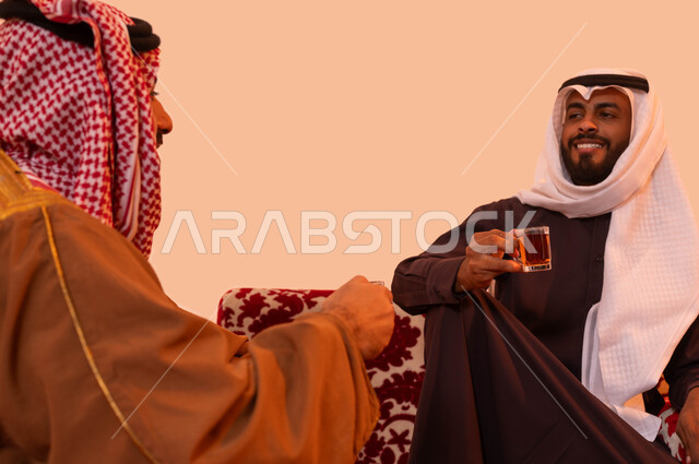 ثقافة المجتمع العربي السعودي في حسن الضيافة ، التواصل والتفاعل وتبادل القصص والضحكات، بورتريه لشباب عربي سعودي خليجي يتبادلون أطراف الحديث أثناء احتساء الشاي،  فعاليات وأجواء ترفيهية، نزهه بريه في الصحراء أثناء الشتاء، خلفية بيج
