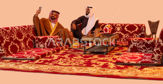 عادات سعودية في حسن الضيافه والكرم، استخدام التقنية الحديثة، بورتريه لشباب عرب خليجية سعودية يقومون بتوثيق اللحظات السعيدة باستخدام الهاتف المحمول، مفهوم الجلسات الشعبية البرية، فعاليات وأجواء ترفيهية، الاستمتاع بالهواء العليل والجلسات المفتوحة، خلفية بيج