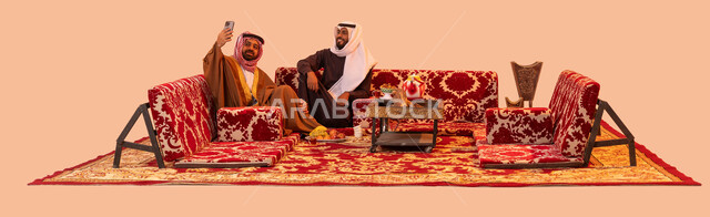 حوارات ونقاشات بين الاصدقاء، جلسات سعودية تقليدية في الهواء الطلق، بورتريه لشابين عربيين خليجيين سعوديين يقومان بتوثيق اللحظات الثمينة باستخدام الهاتف المحمول، الاستمتاع بالأنشطة في الهواء الطلق أثناء الكشتة البرية، خلفية بيج