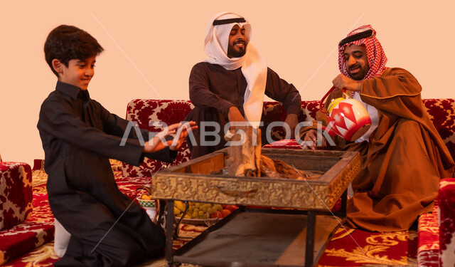 العادات والتقاليد السعودية البدوية الاصيلة، مفهوم الكشتة البرية، بورتريه لشباب عربي سعودي خليجي يقومون بالتواصل وتبادل القصص أثناء احتساء الشاي، التدفئة من خلال شعلة النار، اجواء شتوية في المملكة العربية السعودية، خلفية بيج