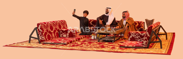 عادات وتقاليد سعودية اصيلة في حسن الضيافه والكرم، استخدام التقنية الحديثة، بورتريه لشباب عرب خليجية سعودية يقومون بتوثيق اللحظات السعيدة باستخدام الهاتف المحمول، مفهوم الجلسات الشعبية البرية، فعاليات وأجواء ترفيهية، الاستمتاع بالهواء العليل والجلسات المفتوحة، خلفية بيج