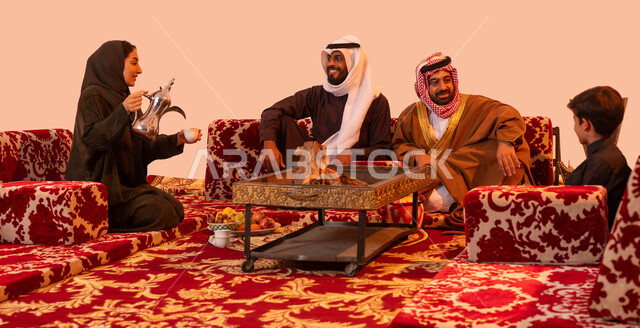 كشته عائلية بدوية تقليدية، الاجتماع حول الموقد الطيني للتدفئة، العادات والتقاليد التراثية في إكرام الضيف، نزهة برية في الصحراء، مفهوم حسن الضيافه والاستقبال، بورتريه لإمرأة عربية خليجية سعودية تستخدم دلة نحاسية لصب القهوة، خلفية بيج.