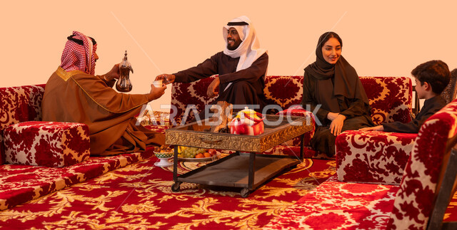 إيماءات البشاشة والترحيب، العادات والتقاليد السعودية العريقة في تقديم القهوة العربية، مفهوم حسن الضيافه والاستقبال، كشتة شعبية خارجية مع الأسرة، بورتريه لعائلة عربية خليجية سعودية في جلسة بر يتبادلون الأحاديث ويتسامرون، خلفية بيج.