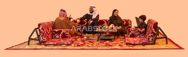 الاستمتاع في الأجواء الشتوية الدافئة أمام الموقد، العادات والتقاليد السعودية العريقة في تقديم القهوة العربية، مفهوم حسن الضيافه والاستقبال، كشتة شعبية خارجية مع الأسرة، بورتريه لعائلة عربية خليجية سعودية في جلسة بر يتبادلون الأحاديث بمحبة وود، خلفية بيج.