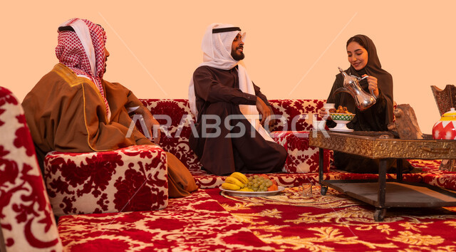 كشتة شعبية خارجية مع العائلة، مفهوم حسن الضيافه والاستقبال، عادات وتقاليد سعودية اصيلة في تقديم القهوة العربية، بورتريه لإمرأة عربية خليجية سعودية مبتسمة ترتدي العباءة تقوم بصب القهوة باستخدام الدلة النحاسية، خلفية بيج.