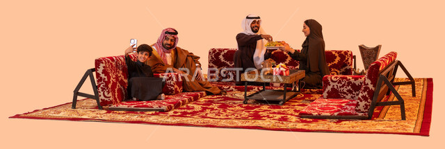 مفهوم حسن الضيافه والاستقبال، استخدامة الأجهزة والتقنيات الحديثة، جلسات شعبية خارجية مع العائلة، عادات وتقاليد سعودية اصيلة، بورتريه لإمرأة عربية خليجية سعودية مبتسمة ترتدي العباءة تقوم بتقديم الفواكه للضيوف، التقاط صور السيلفي التذكارية، خلفية بيج.