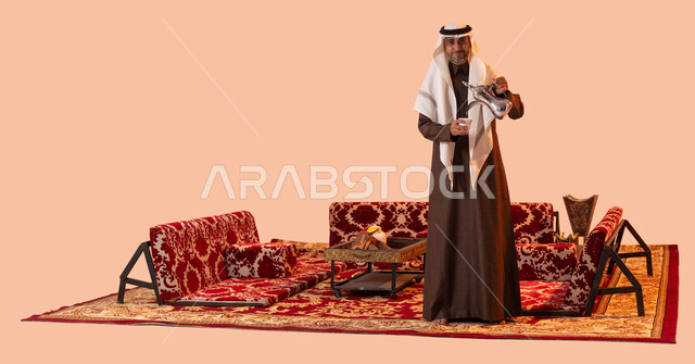 عادات وتقاليد أصيلة في كرم الضيافة، حسن استقبال وإكرام الضيوف، بورتريه لسيد عربي سعودي خليجي مبتسم يرتدي الغترة والثوب التقليدي يقوم بسكب القهوة العربية الساخنة بإيماءات السرور والترحيب، جلسات شعبية خارجية، منتج محلي وطني، صورة الجسم بالكامل، خلفية بيج.
