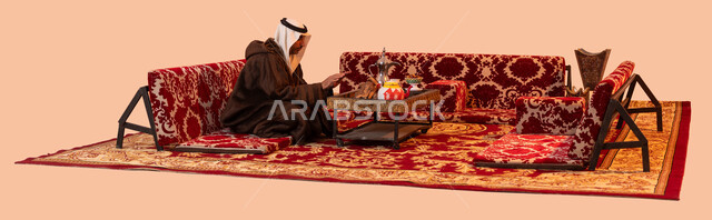 أسلوب الحياة البدوية القديمة, جلسة بر شبابية شعبية، إيماءات التدفئة على الموقد, مخيمات وأجواء شتوية، بورتريه لرجل كبير السن عربي خليجي سعودي يرتدي الزي التقليدي والملابس الشتوية الدافئة يجلس أمام شعلة من النار ، الأجواء الهادئة في أماكن التخييم، خلفية بيج