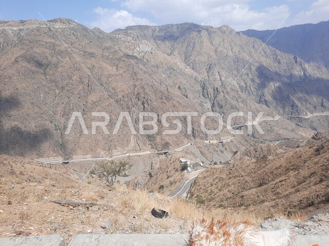 طريق اسفلتي ملتوي بين السلاسل الجبلية المرتفعة، التضاريس والتكوينات الصخرية في قمم ومرتفعات المملكة، انشاء الطرق والشوارع المعبدة في جبال محافظة الباحة، المناظر الطبيعية والاماكن السياحية المشهورة في السعودية