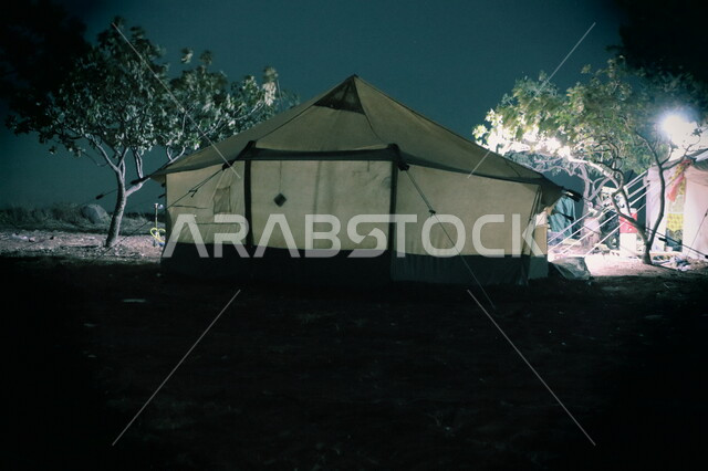 A wild camping trip, the desert environment of camping places in the Kingdom of Saudi Arabia, a youthful camping trip, a close-up of a traditional tent in the desert, enjoying the quiet atmosphere at night time