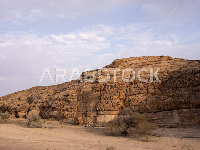 الكثبان الذهبية الرملية الناعمة وضح النهار، الطبيعة الصحراويه في الأماكن السياحية الأثرية المشهورة, البنية الصخرية الطبيعية في منطقة العلا, التكوينات والتشكيلات الحجرية في المملكة العربية السعودية, منظر السماء المليئة بالغيوم البيضاء
