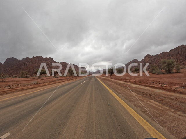 الطرق والشوارع المعبدة بين المناظر الطبيعيه و القمم والمرتفعات الجبلية في قرية توارن في حائل ، الطبيعه الصحراوية و التكوينات الصخرية في السعودية، الكثبان الرمليه الذهبية الناعمة، منظر السماء الملبدة بالغيوم في الاماكن السياحية في المملكة