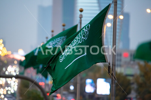 Glorifying the word of monotheism and strengthening national identity, the green flag of the Kingdom of Saudi Arabia flying in the air, Flag Day March 11, celebrating Saudi National Day September 23 and National Day, the concept of love for the homeland and belonging to it, recalling history and showing loyalty to the country.