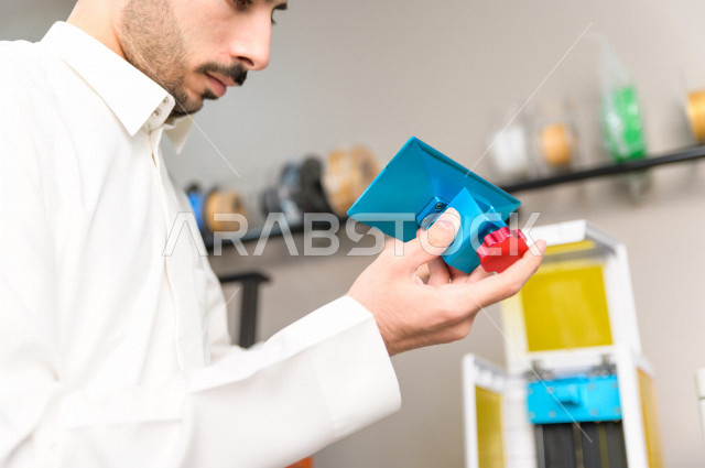 An innovative Saudi young man checks tools and equipment in the laboratory, using artificial intelligence for manufacturing, an academy specializing in science, technology, engineering and mathematics