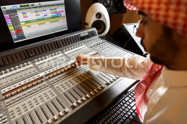 شاب سعودي يعمل كمرسال خارج الاستديو ،يعالج الاصوات المسجلة داخل الاستديو عن طريق برمجيات صوتية من خلال جهاز الحاسوب المخصص ، استديو تسجيل صوتي ، بث مباشر ، فريق الاعداد ، الاذاعة الصوتية ، نشرات اخبارية