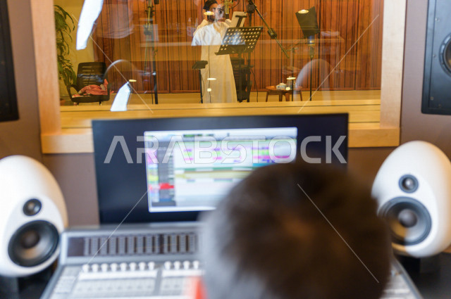 شاب سعودي يعمل كمرسال خارج الاستديو ،يعالج الاصوات المسجلة داخل الاستديو عن طريق برمجيات صوتية من خلال جهاز الحاسوب المخصص ، استديو تسجيل صوتي ، بث مباشر ، فريق الاعداد ، الاذاعة الصوتية ، نشرات اخبارية