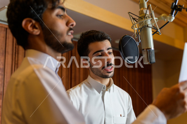 مذيعان سعوديان داخل الاستديو ، تسجيل الصوت من خلال المايكروفون ،  استديو تسجيل صوتي ، بث مباشر ، فريق الاعداد ، الاذاعة الصوتية ، نشرات اخبارية
