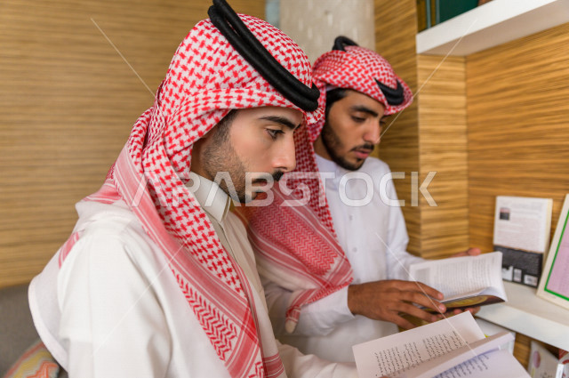 شابان سعوديان مثقفان يقضيان وقتهما في المكتبة و يقرأن الكتب ، قراءه كتب ،  الدراسة في المكتبة