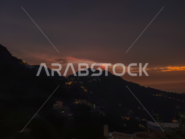 Night weather and the appearance of red twilight in Faifa Governorate in the Jazan region, tourist places in the Kingdom of Saudi Arabia, trees and green plants on the slopes of mountains, natural landscapes in mountain peaks and heights, famous tourist attractions
