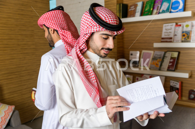 شابان سعوديان مثقفان يقضيان وقتهما في المكتبة و يقرأن الكتب ، قراءه كتب ،  الدراسة في المكتبة
