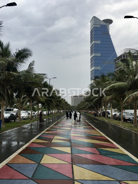 The waterfront in Saudi Arabia, famous tourist attractions, the new Corniche tower in the coastal city, urban growth and development of facilities and skyscrapers in the city of Jeddah, cloudy skies and overcast skies, palm trees and green plants on the roads of tourist cities