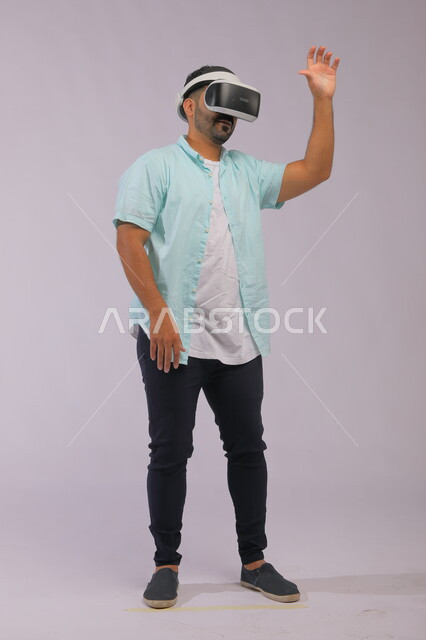 Integrating technology and technology into practical life, a portrait of a Saudi Gulf Arab man wearing casual summer clothes and wearing 3D glasses, conducting interactive experiences through virtual reality glasses, full-length body portrait, white background.