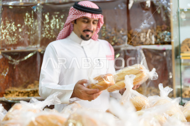 رجل سعودي خليجي يتبضع في قسم المخبوزات داخل السوبرماركت ، شراء الاحتياجات المنزلية ، السلع والمواد غذائية المختلفة ، مستلزمات المستهلك