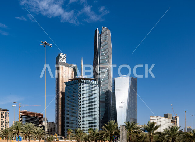 أشجار النخيل الخضراء المحيطة بمركز الملك عبد الله المالي (كافد) في الرياض، الوجهة المثالية للمال والأعمال بمعايير عالمية، فنون وتصاميم هندسية معمارية مميزة للأبراج الاقتصادية وناطحات السحاب، الشركات الراقية الرائدة في الخدمات المصرفية والتكنولوجيا المالية.