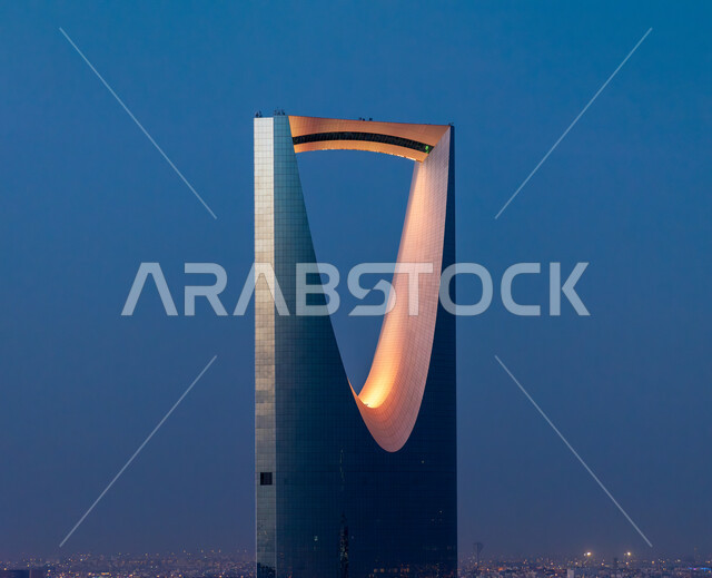 الفن الهندسي المعماري للمنشآت وناطحات السحاب في مدينة الرياض, صورة مقربة لمبنى برج المملكة المضاء باللون البرتقالي في وقت الليل بالسعودية, العمل على تنمية وتطور الأبراج والمباني, أماكن ومعالم السياحة المشهورة