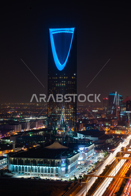 الاستمتاع بالمناظر الليلية الهادئة, الفن الهندسي المعماري للمنشآت وناطحات السحاب في مدينة الرياض, صورة مقربة لمبنى برج المملكة المضاء باللون الأزرق في وقت الليل بالسعودية, العمل على تنمية وتطور الأبراج والمباني, أماكن ومعالم السياحة المشهورة
