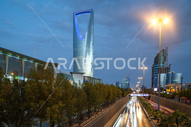 المباني السكنية والتجارية في العاصمة, تطور وتنمية العمران بالمملكة العربية السعودية, حركة مرور السيارات في طريق الملك فهد, أشجار النخيل الخضراء، الهندسة المعمارية الفنية لمبنى برج المملكه في مدينة الرياض, معالم سياحية مشهورة في وقت النهار