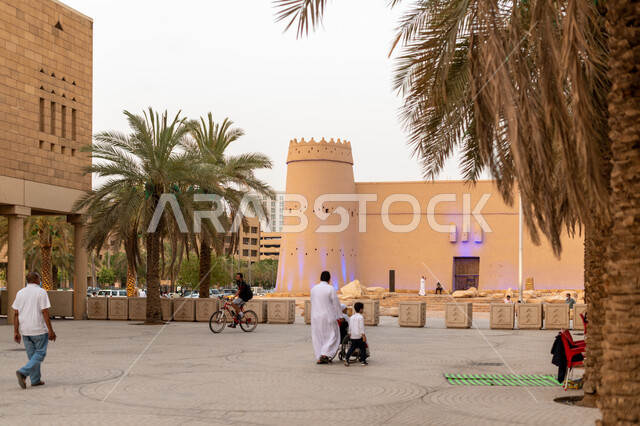 Monuments and tourist archaeological sites in Saudi Arabia, mud buildings and ancient buildings, nobility, authenticity and adherence to Saudi heritage, the historical status of the Masmak Fort, the courtyards of the Palace of Governance area in the city of Riyadh, the social meeting place for the residents of the capital, green palm trees.