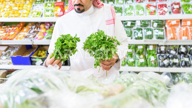 رجل سعودي خليجي يتبضع في قسم الخضراوات داخل السوبرماركت ، شراء الاحتياجات المنزلية ، السلع والمواد غذائية المختلفة ، مستلزمات المستهلك