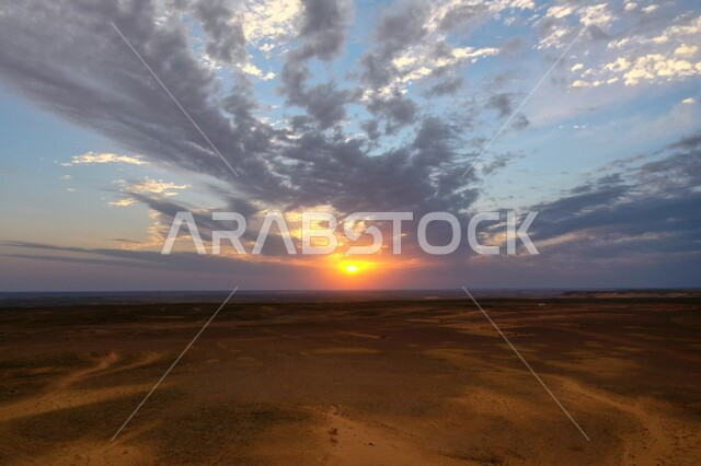 غروب الشمس على الرمال الذهبيه الناعمة في المملكة العربية السعودية، المناظر الطبيعية قي صحراء شمال الرياض، منظر السماء المليئة بالغيوم البيضاء، خلفية البيئة الصحراوية