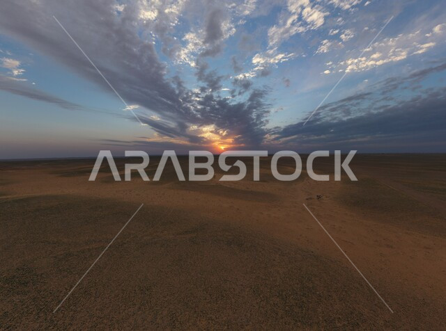 المناظر الطبيعية قي صحراء شمال الرياض، غروب الشمس على الرمال الذهبيه الناعمة في المملكة العربية السعودية، منظر السماء المليئة بالغيوم البيضاء، خلفية البيئة الصحراوية