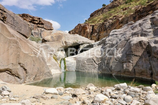 Landscapes in the famous distinctive amusement parks, an important natural tourist site in Mecca in the Kingdom of Saudi Arabia, the high rocky stones in the Wadi Dahab Waterfalls in Al-Laith Governorate, the view of the sky with white clouds