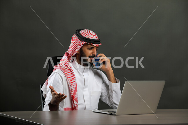 إيماءات الغضب واللوم والتأنيب، التهيج والتوتر والضغط، الاستفسار والسؤال عن شيء ما، بورتريه لرجل أعمال عربي  سعودي خليجي يرتدي الشماغ والثوب التقليدي يجري مكالمة هاتفيه باستخدام الهاتف المحمول، عدم الالتزام بالمخططات والاتفاقيات ، خلفية رمادية .