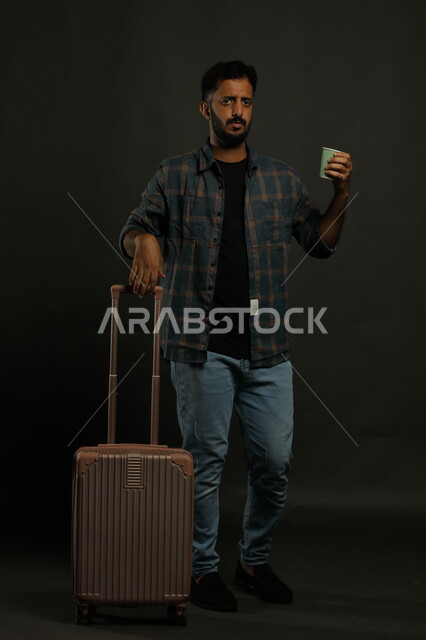 الابتعاد عن ضغوط الحياة، بورتريه لرجل عربي سعودي خليجي يرتدي الزي الكاجوال يمسك بيده كوب قهوة ورقي وينظر الى الكاميرا بجدية، الاستمتاع بالعطلة الصيفية، مفهوم السياحة والسفر، صورة للجسم بالطول الكامل، خلفية رمادي