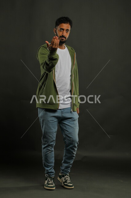 شرح العروض التقديمية ، التحضير لمشروع التخرج ، بورتريه لرجل عربي خليجي سعودي يرتدي الزي الكاجوال ويشير بيده لأحد ما، ايماءات الاقتراب وطلب التقدم، صورة الجسم بالطول الكامل، خلفية سوداء