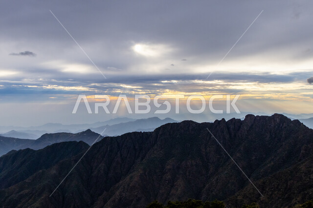 Tranquility and peace in the peaks and highlands, sunset moments over the Soudah Mountains in the Asir region, southwest of the Kingdom of Saudi Arabia, a stunning view of the cloudy sky, famous tourist places and attractions.