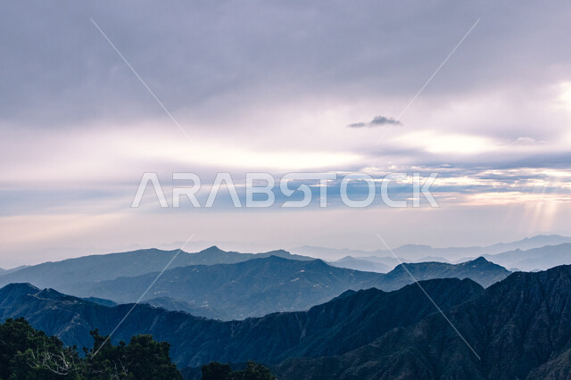 البيئة الطبيعيه في المرتفعات والهضاب، لحظات غروب الشمس فوق جبال السودة بمنطقة عسير جنوب غرب المملكة العربية السعودية، منظر خلاب للسماء الملبدة بالغيوم، أماكن ومناطق سياحية مشهورة